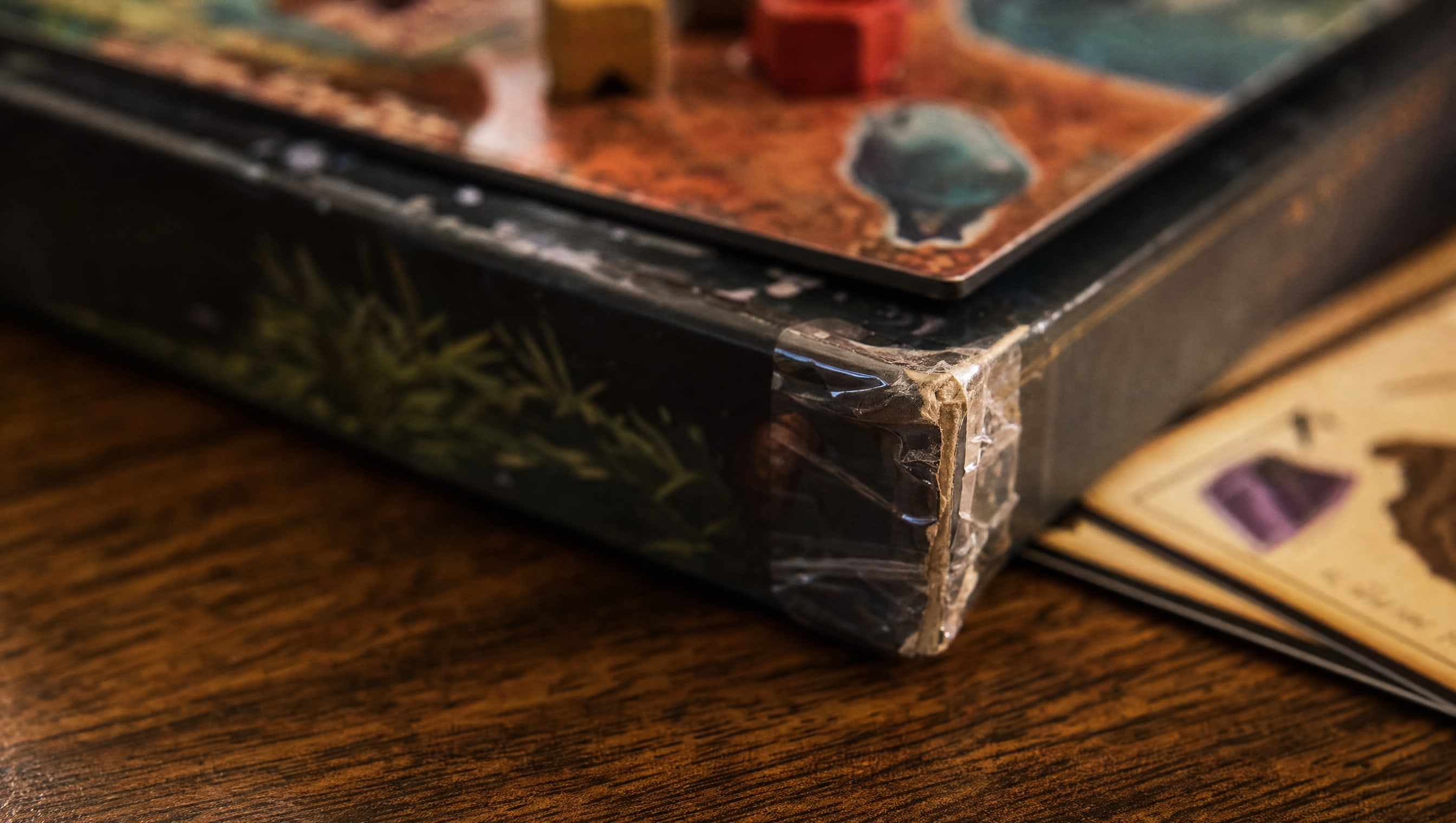 A repaired box corner, photographed close, with the crease still visible under the lamp.