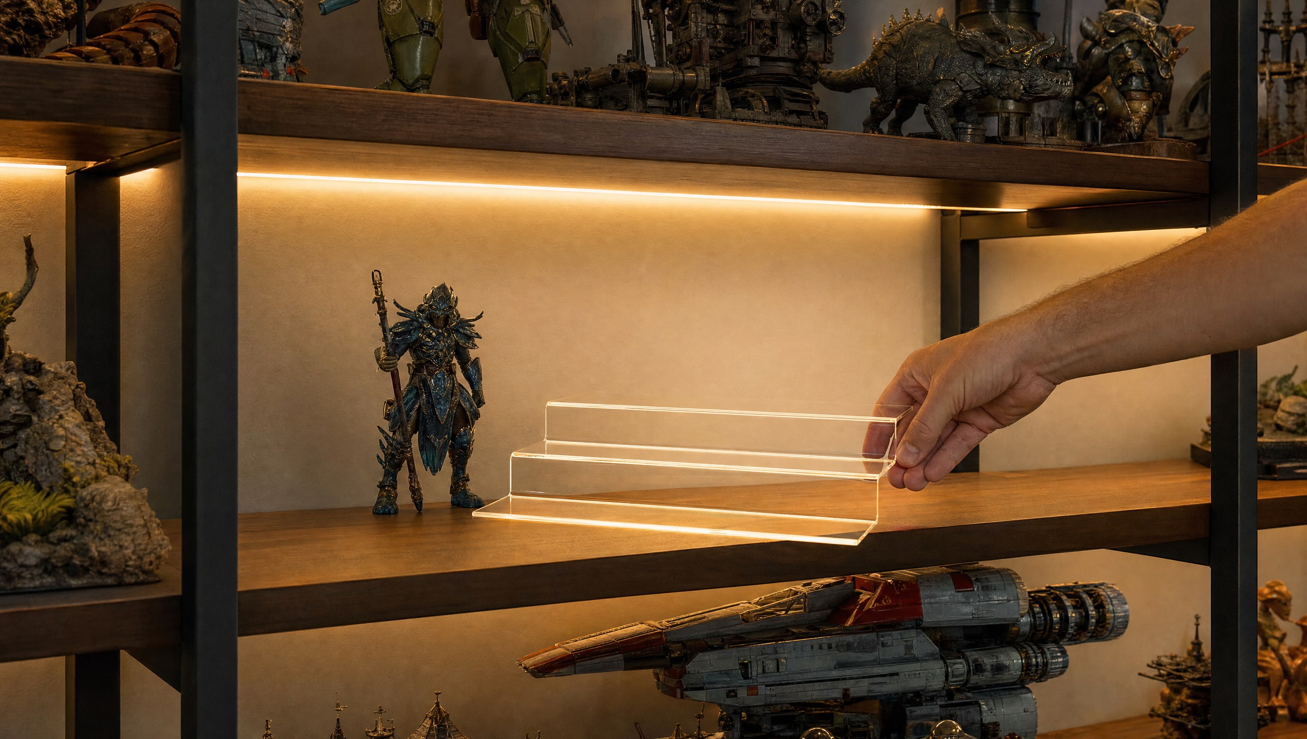 A hand setting an acrylic riser down on a shelf, a figure waiting beside it.