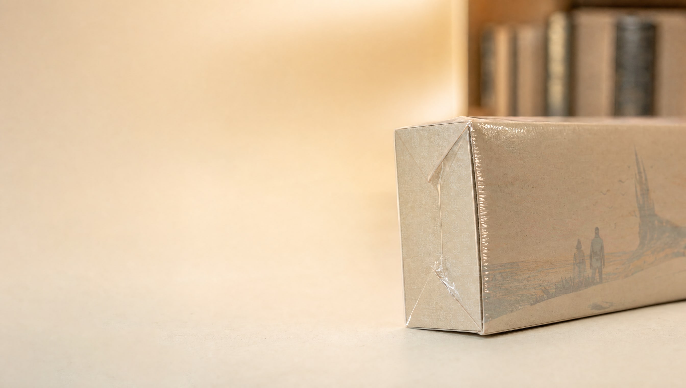 A sealed invented game carton lying under a raking light, the shrink film catching a faint repeating pattern across the corner.